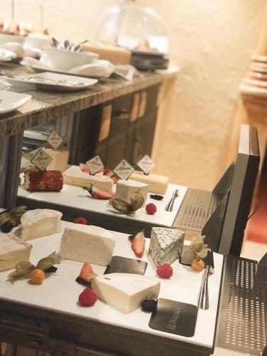 a bunch of different types of cheeses on a table at Superior Hotel Post Ischgl in Ischgl