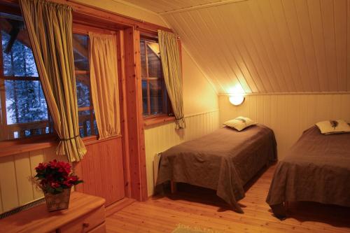 KiviperäにあるWilderness Chalet Kuusamoのベッドルーム1室(ベッド2台、窓付)