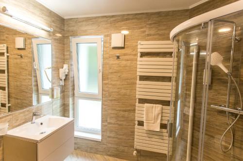 a bathroom with a shower, sink, and toilet at Panorama Boutique Hotel in Sfântu-Gheorghe