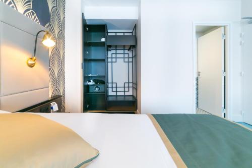 a bedroom with a white bed and a mirror at Best Western Hôtel Journel Antibes Juan-les-Pins in Antibes