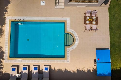 an overhead view of a swimming pool with chairs and a table at Thelxis Villa in Lourdhata