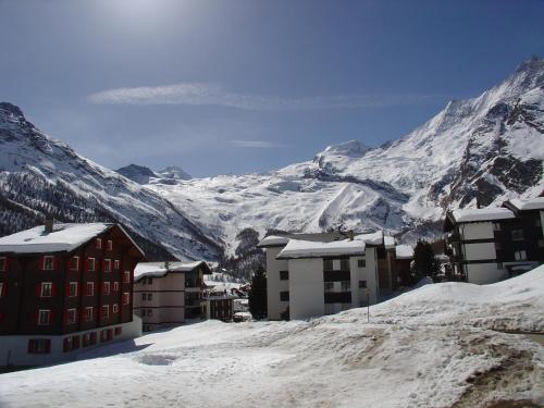 a snow covered mountain with buildings and snow covered buildings at Hotel Europa in Saas-Fee