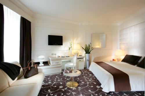 a hotel room with a bed and a couch at Etrusco Arezzo Hotel - Sure Hotel Collection by Best Western in Arezzo