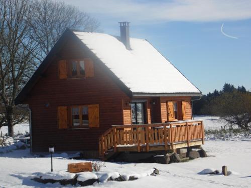a log cabin with a snow covered roof at Chalet des Clarines in Saint-Genès-Champespe