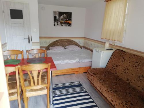 een woonkamer met een bed en een tafel en stoelen bij Domek letniskowy Mauritius in Mielno