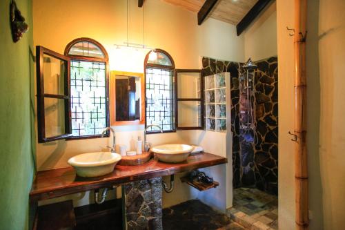 a bathroom with two sinks and two mirrors at Casa Marbella in Santa Teresa Beach