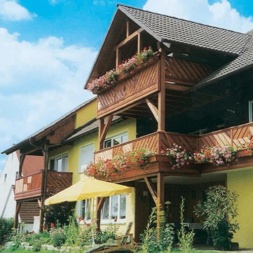 una casa con un balcón con flores. en Ferienhof Weydringer, en Haundorf