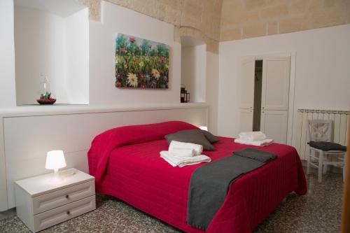 una camera con un letto rosso e un dipinto sul muro di Il Rifugio di Laerte a Laterza