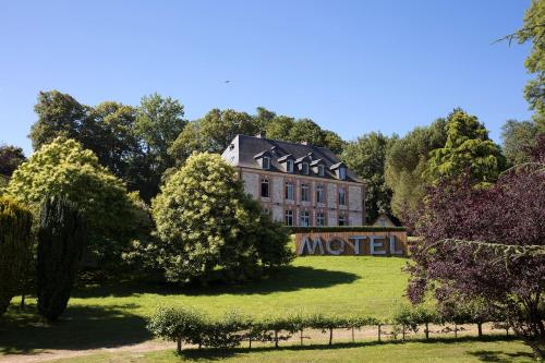 
a large house with a large clock on the front of it at Le Manoir de la Plage / Adults Only in Honfleur
