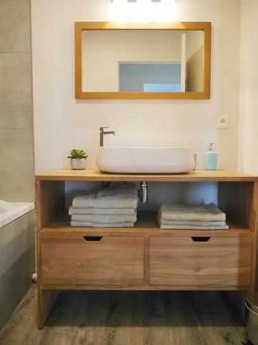 une vanité de salle de bain avec un lavabo et un miroir dans l'établissement Au cœur du Bassin d'Arcachon, à Gujan-Mestras