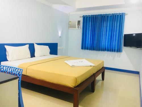 a small bedroom with a bed with a blue curtain at Kalluvalappil Holiday Inn in Kāsaragod