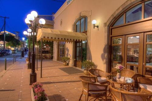 a sidewalk with a table and chairs outside of a building at Fortezza Hotel in Rethymno Town