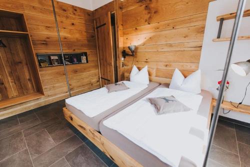 two beds in a room with wooden walls at Luxus-Chalet am Fluss in Schwarzach bei Nabburg