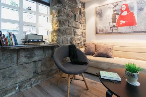 a living room with a chair and a stone wall at GreenKey Apartment SK2 in Reykjavík
