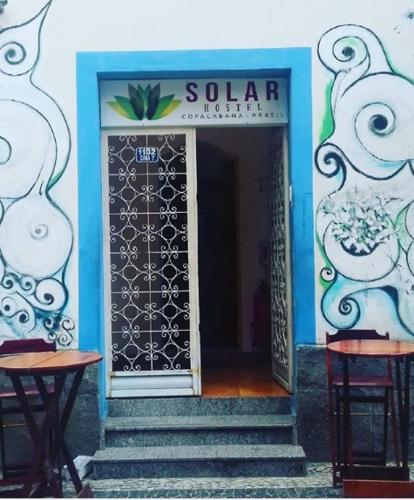 a door to a building with two stools in front at Solar Hostel Beach Copacabana in Rio de Janeiro