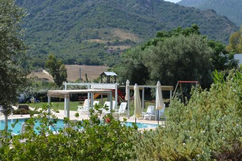 a pool with chairs and umbrellas in a resort at Hotel Cardedu in Cardedu