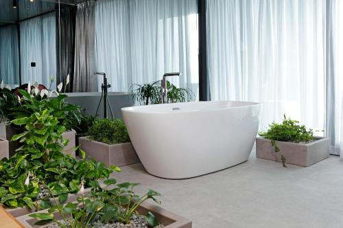 a bath tub in a room with potted plants at Lifestyle Hotel Vitar - Adults Only in Bol