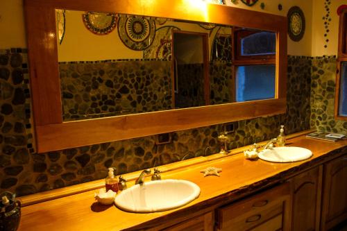 Un baño con dos lavabos y un espejo grande. en Hospedaje Andorra La Vella, en Ushuaia