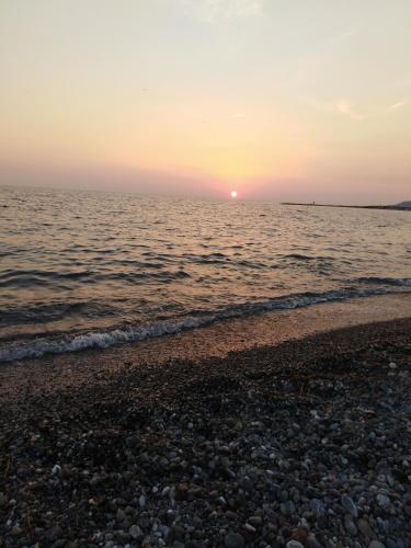 a sunset over the ocean with a rocky beach at Appartamenti Don Guglie' in Cetraro