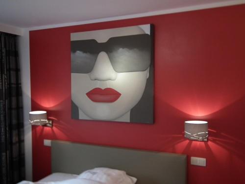 a red wall with a picture of a woman with red lipstick at Holiday Home New Largo in Nieuwpoort