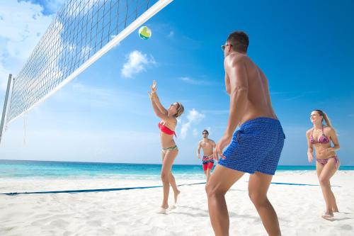a group of people playing volleyball on the beach at Golden Parnassus Resort & Spa - All Inclusive (Adults Only) in Cancún