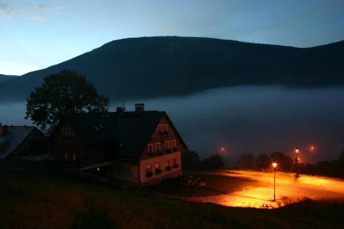 a house sitting on top of a hill at night at Pension Slunečnice & Panorama Restaurace Farma in Špindlerův Mlýn