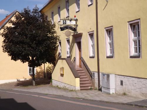 un edificio amarillo con escaleras a un lado en Hotel "Zur Sonne", en Querfurt