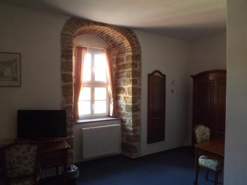 Habitación con ventana y pared de ladrillo. en Hotel "Zur Sonne", en Querfurt