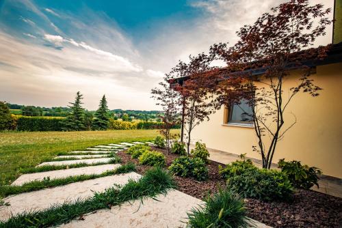 un jardin avec un chemin en pierre à côté d'une maison dans l'établissement Agriturismo Olistico Atman, à Monzambano