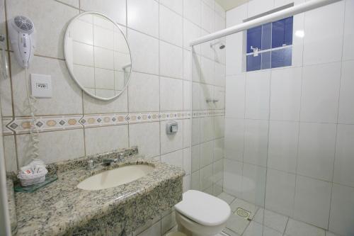 a bathroom with a sink and a toilet and a mirror at Hotéis Pamplona in Rio do Sul