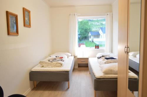 two beds in a room with a window at Apartment 2, Herand, Hardanger in Herand