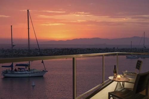 a boat in the water at sunset on a balcony at The Portofino Hotel & Marina, a Noble House Hotel in Redondo Beach