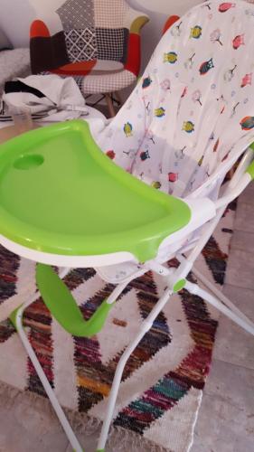 a green and white high chair sitting on a rug at Apartment for Family 2 in Kallithea Halkidikis