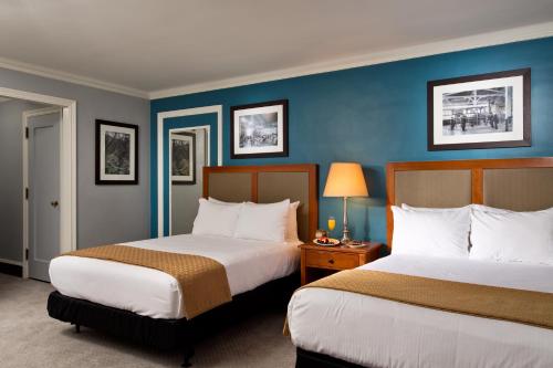 two beds in a hotel room with blue walls at Gideon Putnam Resort & Spa in Saratoga Springs