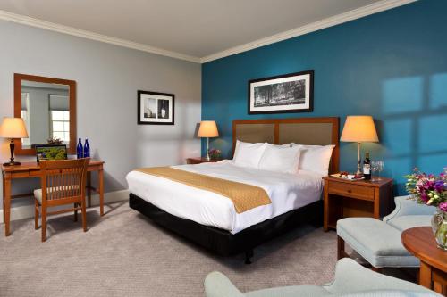 a bedroom with a large bed and a blue wall at Gideon Putnam Resort & Spa in Saratoga Springs