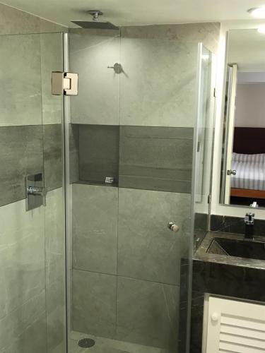 a shower with a glass door next to a sink at Departamento 523 con playa dentro de Hotel en Ixtapa in Ixtapa