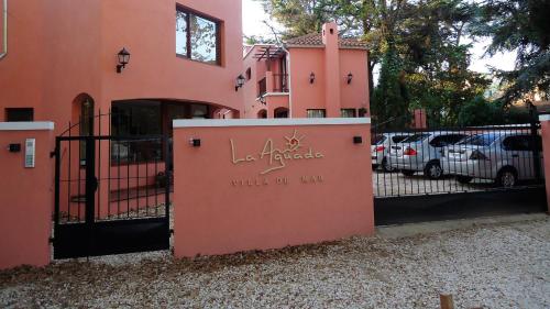 un edificio rosa con una reja con las palabras muro de abrazo en LA AGUADA - Villa de Mar en Villa Gesell