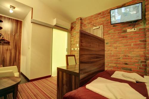 a hotel room with a brick wall and a bed at Browar CzenstochoviA Hotel&Spa in Częstochowa