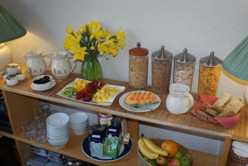a shelf with breakfast foods and flowers on it at The Norwood Guest House in Southport