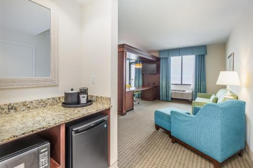a hotel room with a blue chair and a living room at Hampton Inn & Suites - Orange Beach in Orange Beach