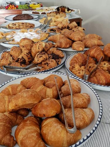 a table topped with plates of pastries and pies at Villaggio La Pescaccia in San Clemente