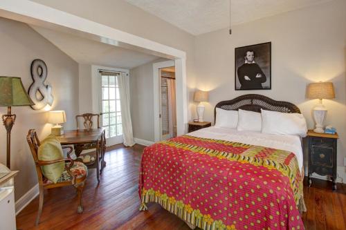 ein Schlafzimmer mit einem Bett mit einer roten und gelben Decke in der Unterkunft Inn on the Riverwalk in San Antonio