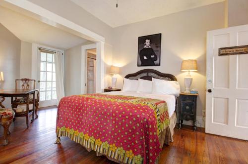 a bedroom with a bed with a red and yellow blanket at Inn on the Riverwalk in San Antonio