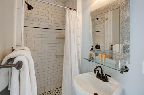 a white bathroom with a sink and a mirror at Inn on the Riverwalk in San Antonio