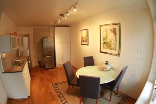 a kitchen and dining room with a table and a refrigerator at Apartment Bystranda - City Beach in Kristiansand