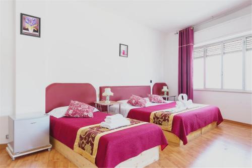 a bedroom with two beds with pink sheets at Ciclamino Siracusa in Syracuse