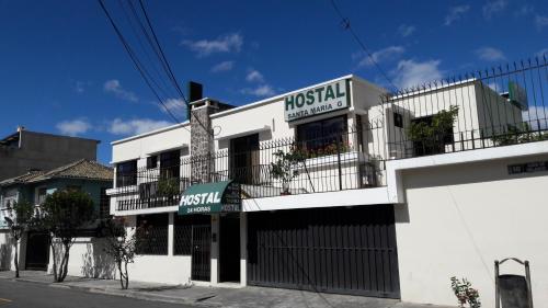 a white building with a sign for a restaurant at Hostal Santa María Gracia in Quito