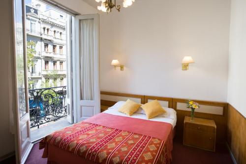 a bedroom with a bed and a large window at Novel Hotel in Buenos Aires