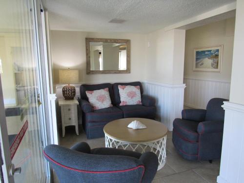 a living room with a blue couch and chairs at Surf Side Hotel in Nags Head