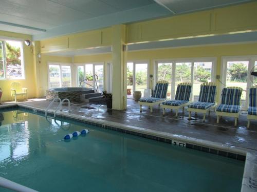 a large swimming pool with chairs and a swimming pool at Surf Side Hotel in Nags Head